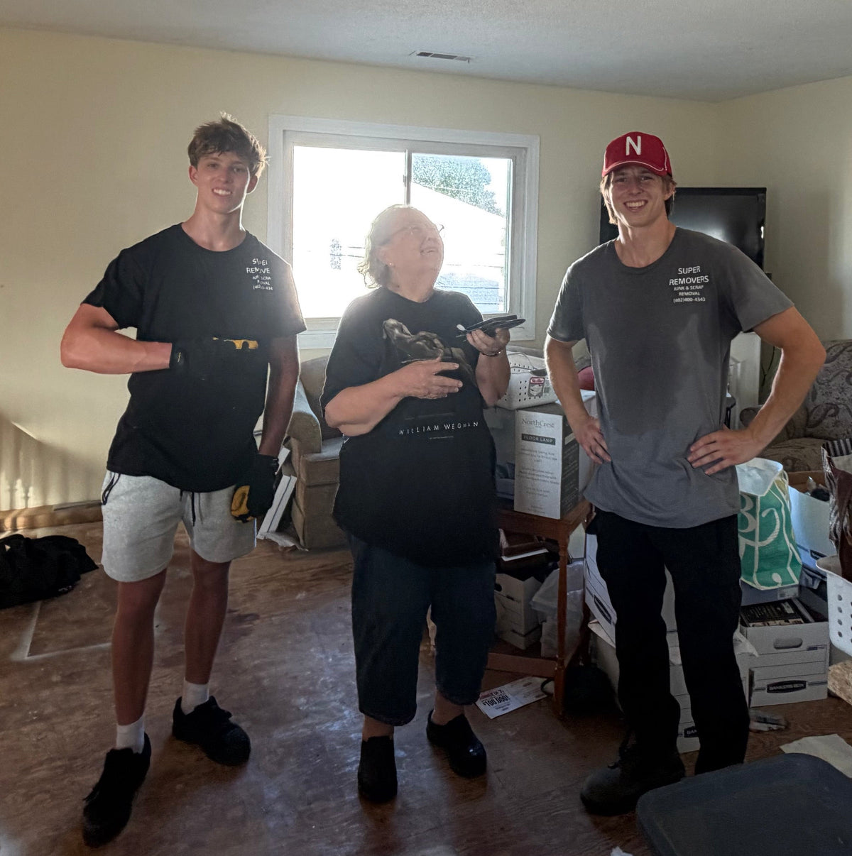 Two Super Removers standing with a customer after finishing a junk removal job.